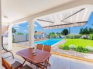 A covered outdoor area with a pool, a table, and chairs. - Serene Escape Near Zadar With Private Pool & Charming Outdoor Oasis (Policnik)