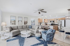 A modern living room with a sectional sofa, a coffee table, and patterned armchairs.