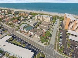 Vista aérea de un pueblo costero con edificios, carreteras y una playa.