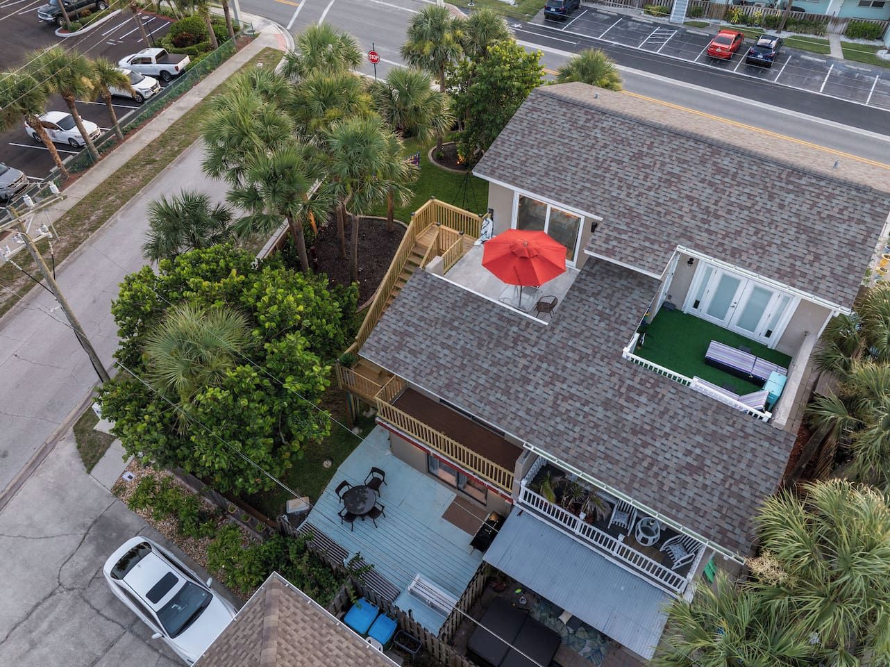 A two-story house with a deck, a covered patio, and a small outdoor seating area.