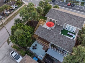 Une maison à deux étages dotée d’une terrasse, d’un patio couvert et d’un petit espace extérieur aménagé pour s’asseoir.
