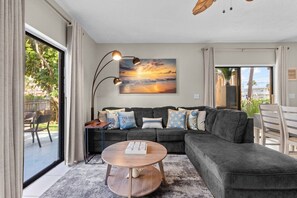 A modern living room with a grey sofa, a round coffee table, and a floor lamp. - Pre/Post Cruise Beach Getaway Near Port Canaveral (Cape Canaveral)