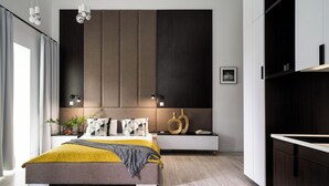 A modern bedroom with a large bed, bedside tables, and a built-in wardrobe.