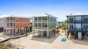 A beachfront property with multi-story buildings, balconies, and a sandy beach.