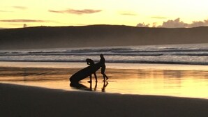 Una spiaggia con una tavola da surf e una persona.