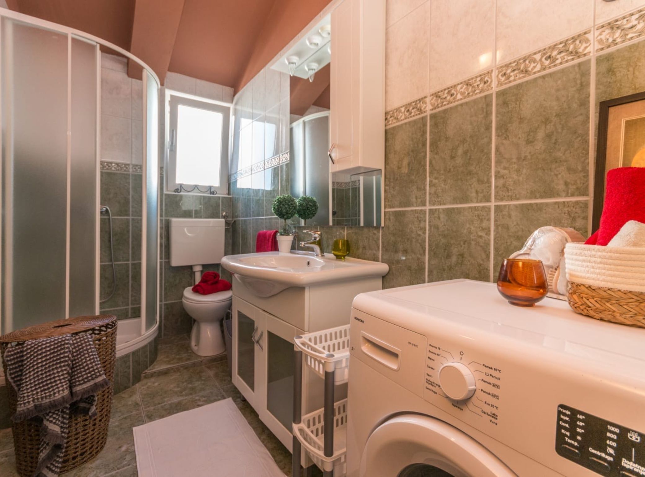 Une salle de bain moderne équipée d’une douche, de toilettes, d’un lavabo et d’un lave-linge.