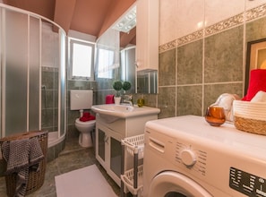 A modern bathroom with a shower, toilet, sink, and washing machine. - Villa Julia (Biograd na Moru)