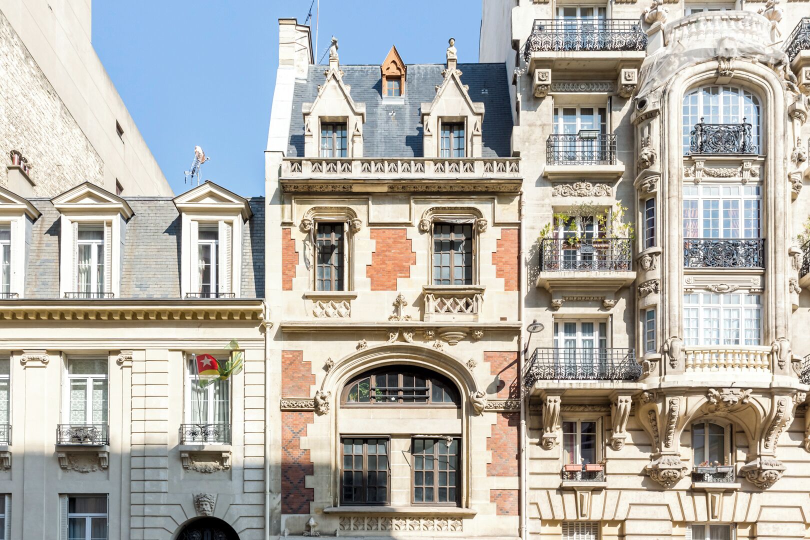 Een rij historische gebouwen met versierde gevels, grote ramen en decoratieve balkons.