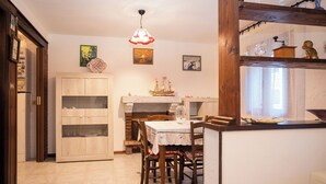 Un comedor acogedor con una mesa de madera, sillas y un modelo decorativo de barco en una repisa.