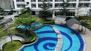 Un bâtiment moderne doté d’une grande piscine au design original, avec des motifs bleus et blancs.