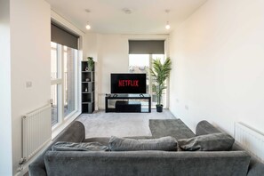Relax in this stylish living room with a large flat-screen TV, comfortable sofa, and a beautiful view.