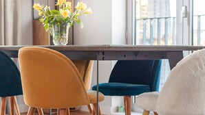 A dining area with a table, chairs, and a vase of yellow flowers. - Perfectly Located Comfy 1-Bed in London Bridge - Pass the Keys (London)