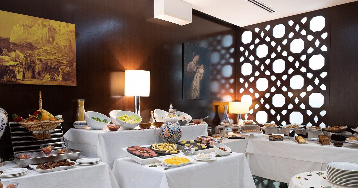 A buffet setup with various food items and a decorative wall with geometric cutouts.