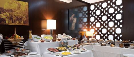 A buffet setup with various food items and a decorative wall with geometric cutouts.