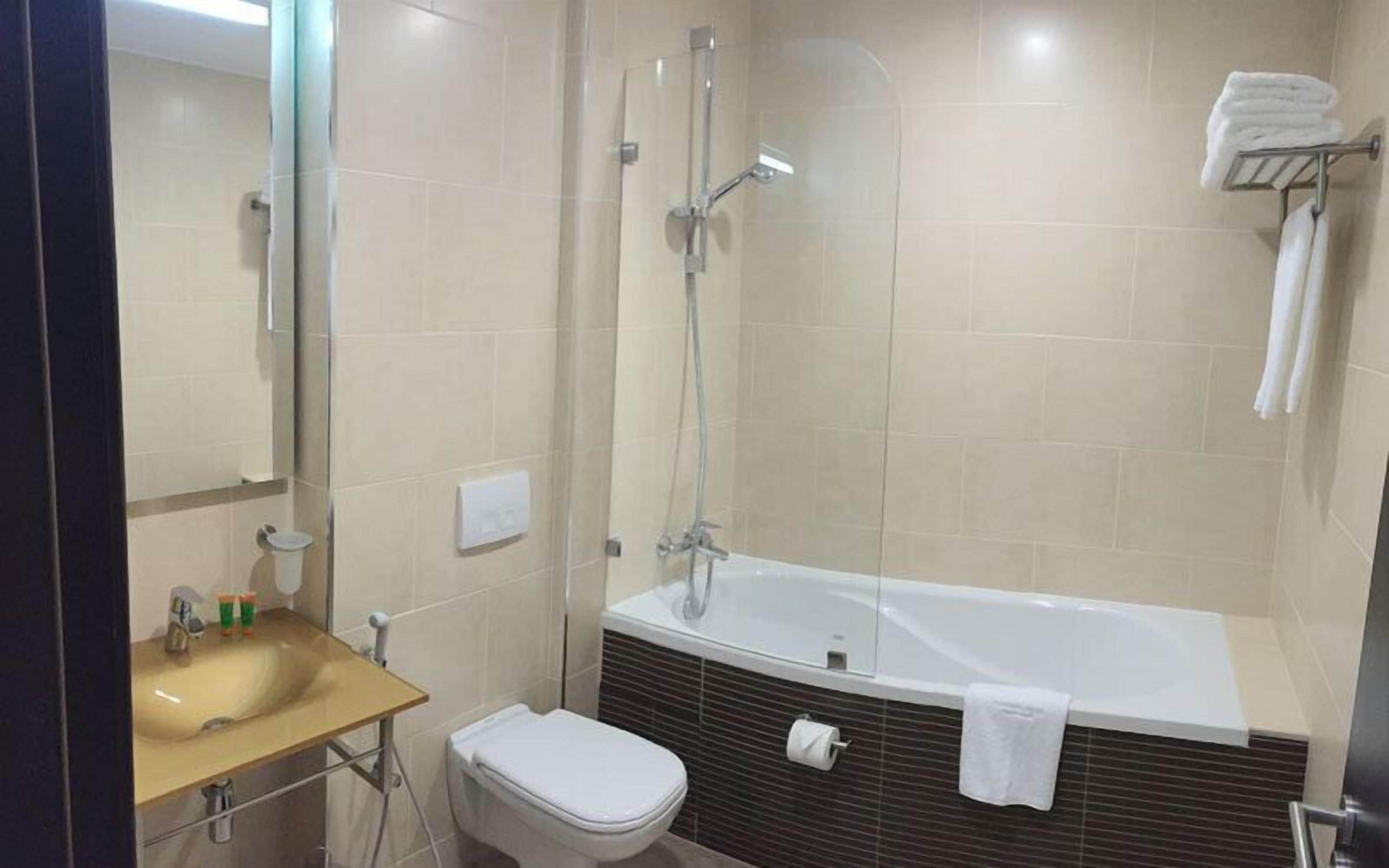 Uma casa de banho moderna com banheira, sanita e lavatório.