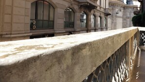 A stone balustrade with a metal railing, part of a building with classical architecture, including arched windows and decorative moldings. - Casa Milano Classic Elegance with Balcony (Milan)