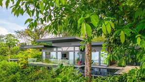 A modern house with a glass balcony, surrounded by lush greenery. - Modern 5BR Villa • Sunset Views • Near Dominical (Hatillo de Aguirre)