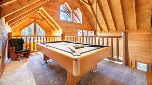 A wooden interior with a pool table, a chair, and a railing. - *Spacious 4BD Lodge w/ POOL! Hot Tub + GAMES!* (Sevierville)