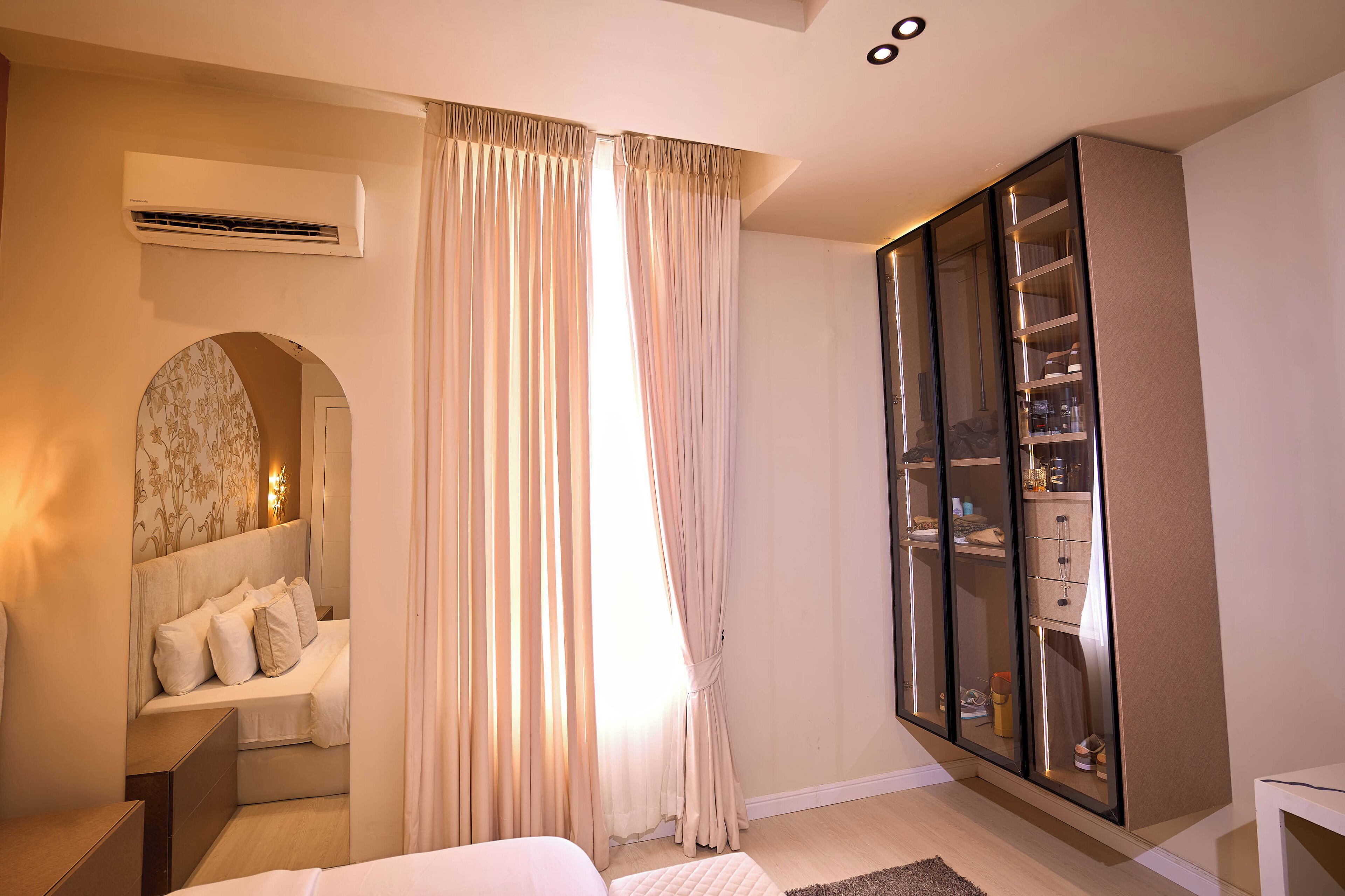 Un dormitorio con cama, armario y espejo.
