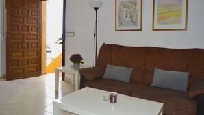 A living room with a patterned sofa, a white coffee table, a floor lamp, and two framed artworks on the wall. - Apartments Taravilla 3D P26, in Bahia Beach (Puerto de Mazarrón)