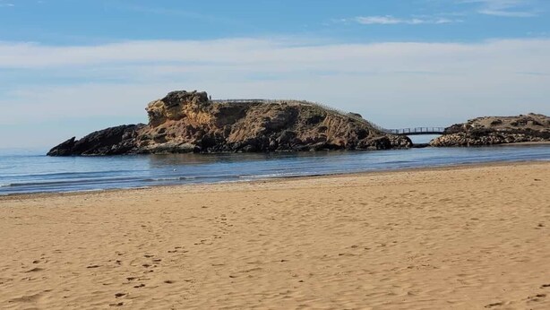 A sandy beach with rocky formations and a bridge. - Apartments Taravilla 3D P26, in Bahia Beach (Puerto de Mazarrón)