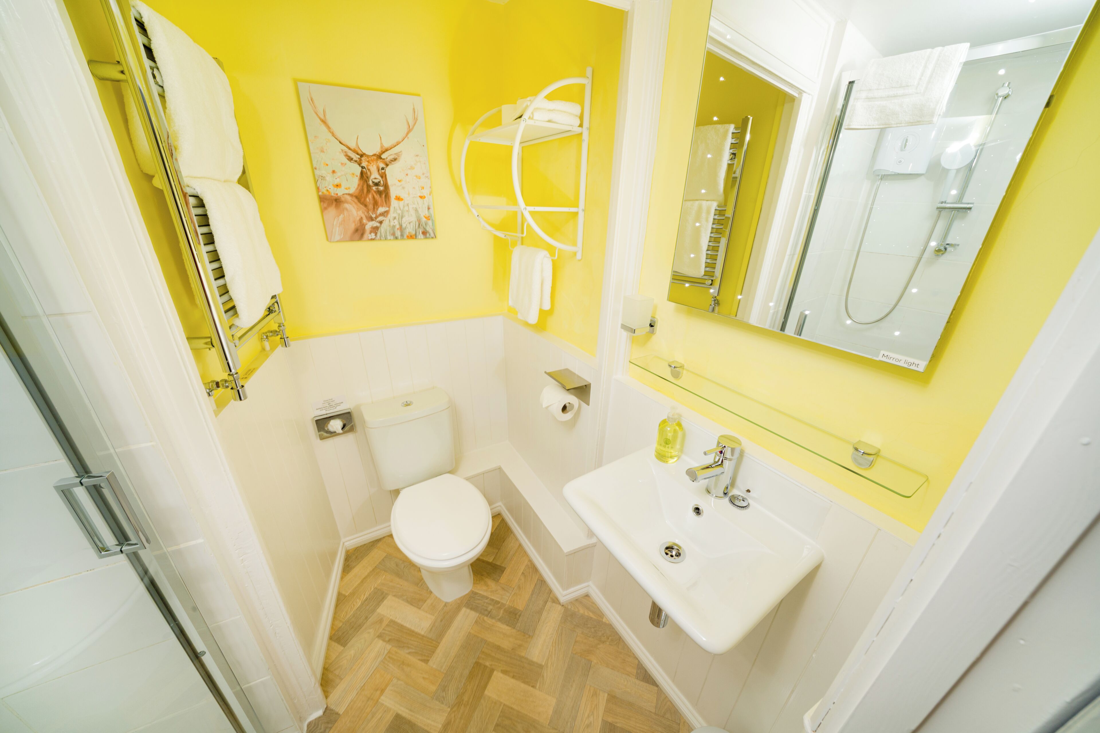 A bathroom with a toilet, sink, and shower.