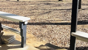 Een open gebied met banken en bomen, waarschijnlijk een park of recreatieruimte.