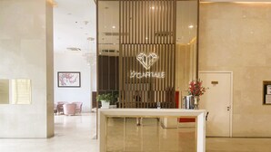 A reception desk with a modern design, a potted plant, and a framed picture on the wall. - HN APT Vinhomes D'capitale Elegance (Hanoi)