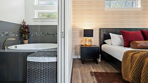 A modern bathroom with a freestanding bathtub, a large mirror, and a stone mosaic backsplash. - Casa Sueño: Pool |SPA| Outdoor Movie ~ Golf Course (Austin)