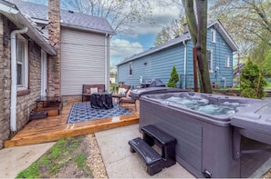 Relax in the hot tub surrounded by a seating area and beautifully manicured grounds.
