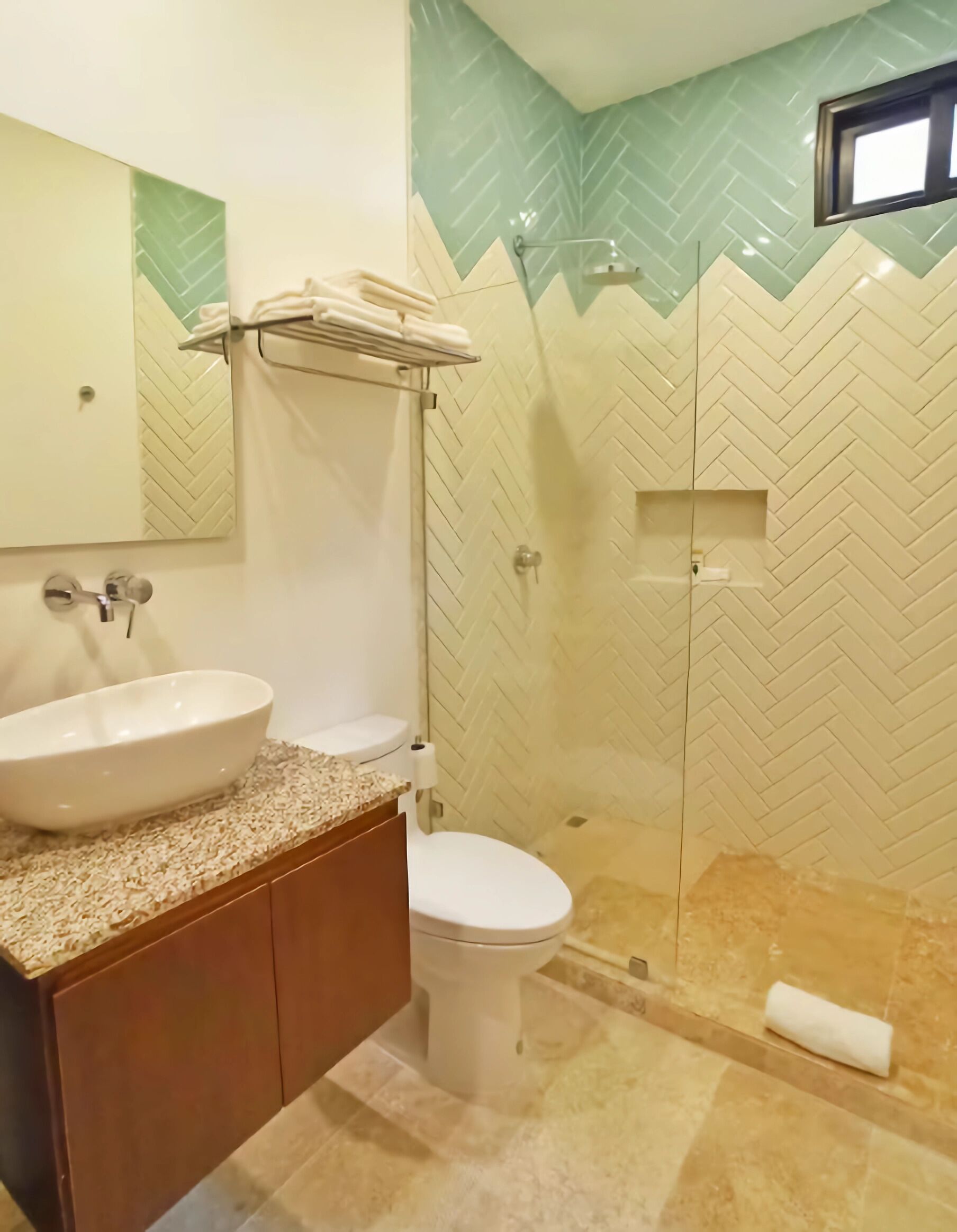 A bathroom with a large sink, toilet, and shower area.