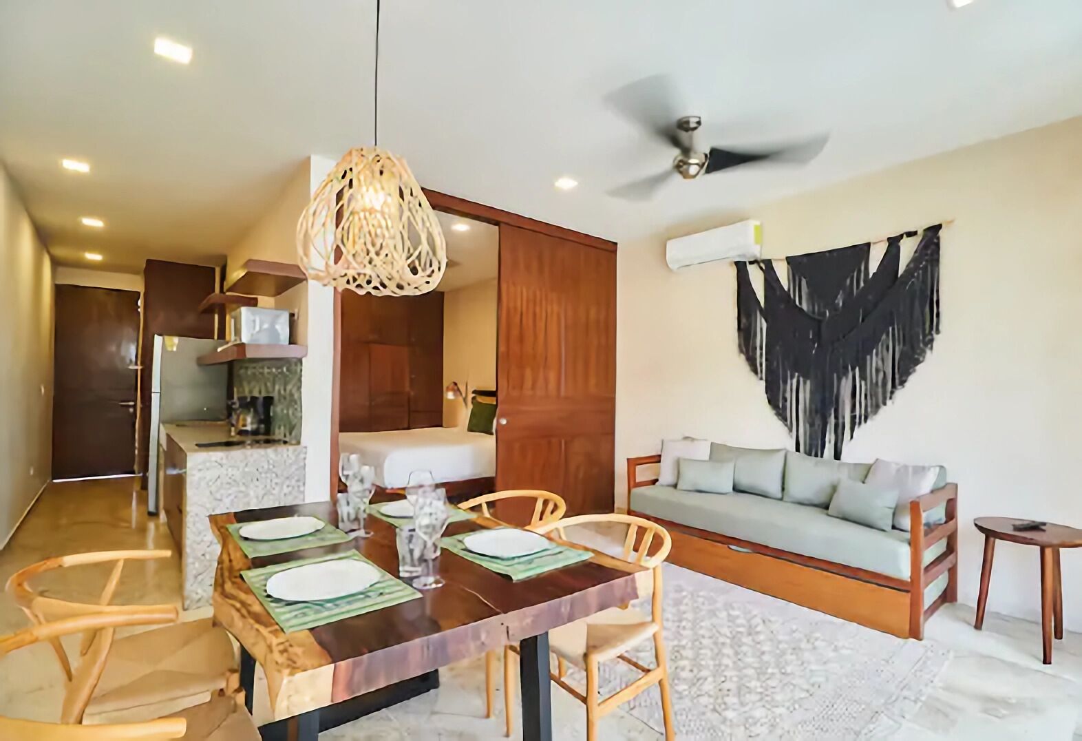 A modern living room with a dining area, a ceiling fan, and a large abstract painting on the wall.
