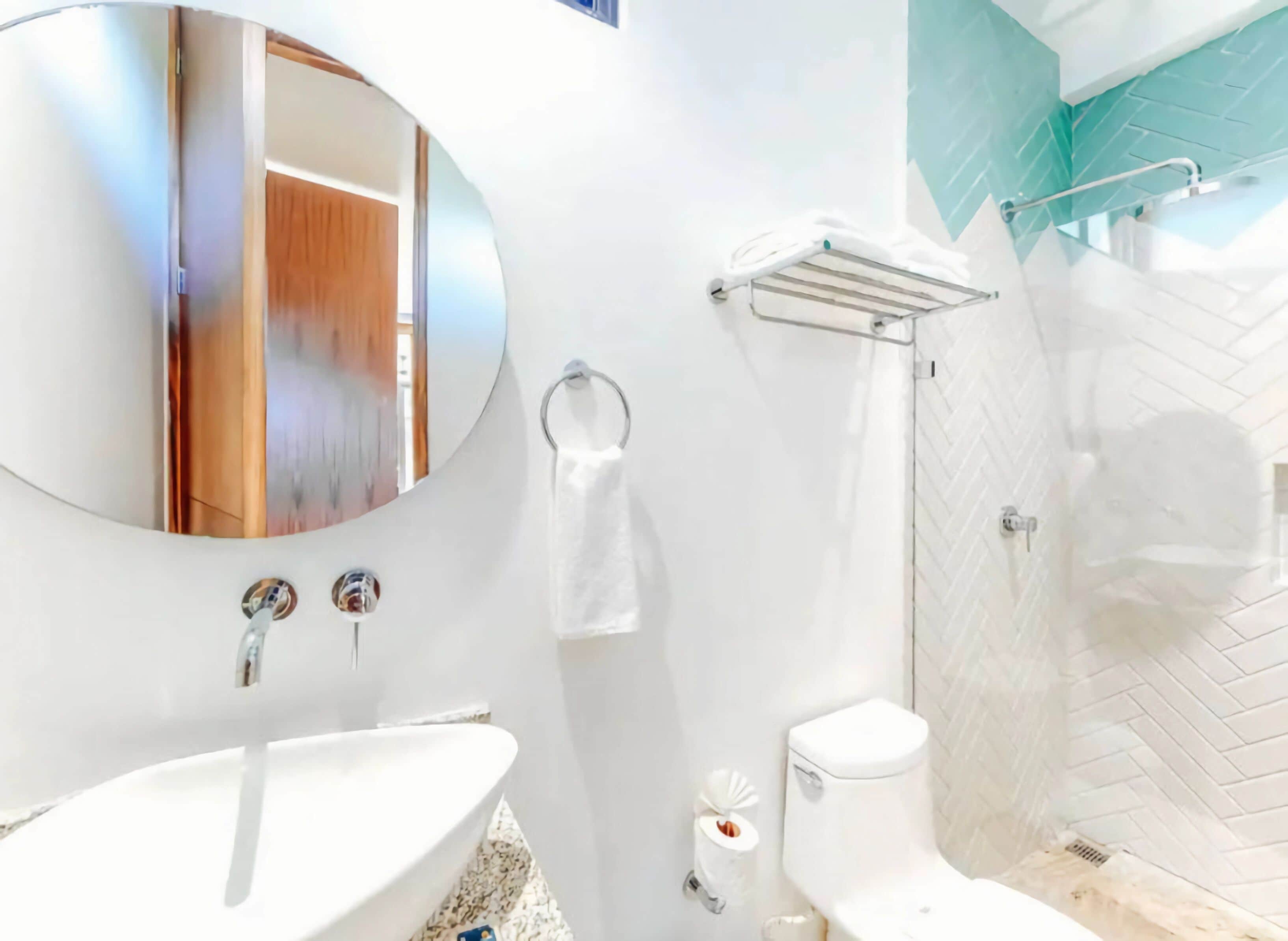 A modern bathroom with a white sink, toilet, and shower.