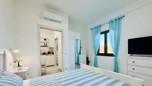 A bedroom with a bed, a TV, a dresser, and a window with curtains. - YourHome - Relais Sant'Anna (Vico Equense)
