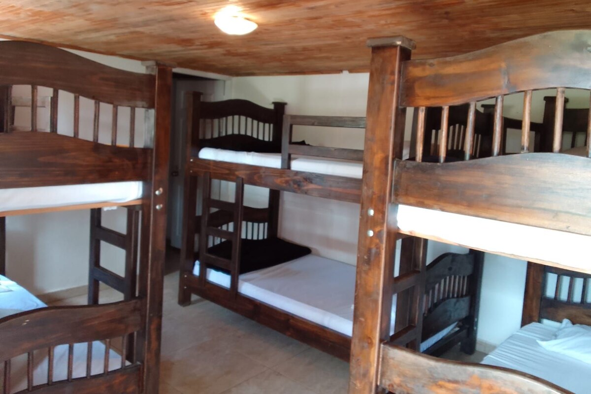 A bunk bed room with wooden frames and white bedding.