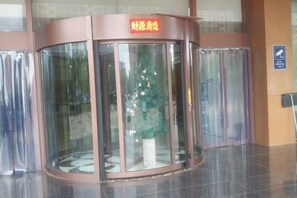 A revolving door with a sign above it. - Jinjing Business Hotel (Linshu)
