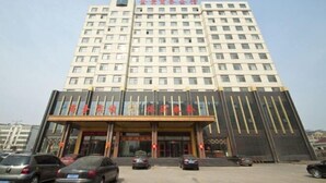 Ein mehrgeschossiges Hotel mit moderner Fassade, das einen markanten Eingang mit Glasüren und eine Reihe von Fenstern in jeder Etage zeigt.