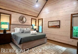 Un dormitorio con una cama grande, dos mesitas de noche, un espejo y un cuadro en la pared.