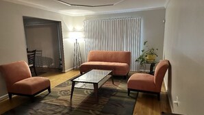 A living room with a sofa, armchairs, a coffee table, and a rug. - Spacious 4-bedroom house in nice Oxon Hill with WiFi, fitness room (Oxon Hill)