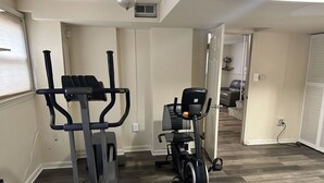 A home gym with an elliptical and a stationary bike. - Spacious 4-bedroom house in nice Oxon Hill with WiFi, fitness room (Oxon Hill)