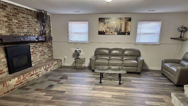 A living room with a fireplace, a leather sofa, and a coffee table. - Spacious 4-bedroom house in nice Oxon Hill with WiFi, fitness room (Oxon Hill)
