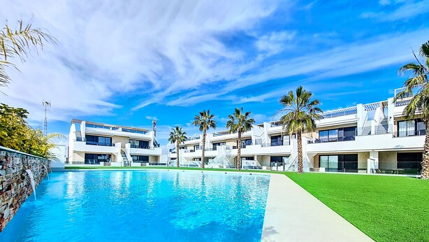 A modern hotel with a swimming pool, palm trees, and a clear blue sky. - Penthouse with private roof terrace (Mar de Cristal)