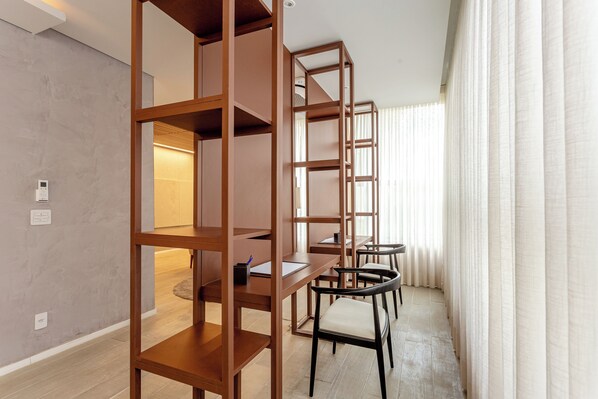 A modern room with wooden shelving units, a desk, and chairs. - Moderno-Pinheiros -AC - Brazilian Corner (São Paulo)