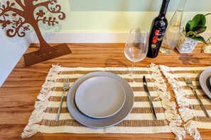 A dining table set with plates, cutlery, and a wine bottle. - Moderno-Pinheiros -AC - Brazilian Corner (São Paulo)