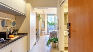 A modern kitchen with a dining area, a small table, and a potted plant. - Moderno-Pinheiros -AC - Brazilian Corner (São Paulo)