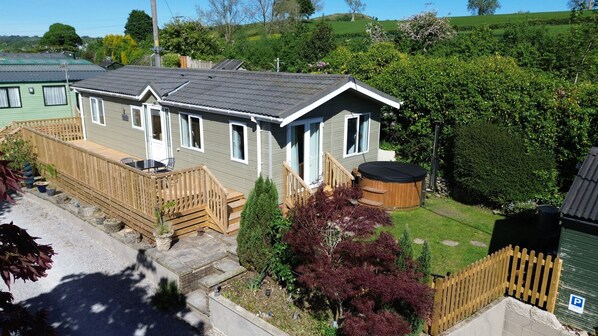 A single-story house with a deck, a hot tub, and a fenced yard.