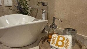 Un lavabo de salle de bain avec un distributeur de savon et un porte-serviettes.