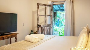 A bedroom with a bed, a television, a window with curtains, and a ceiling fan. - Awe Villa Boutique e Beach Club (Porto Seguro)