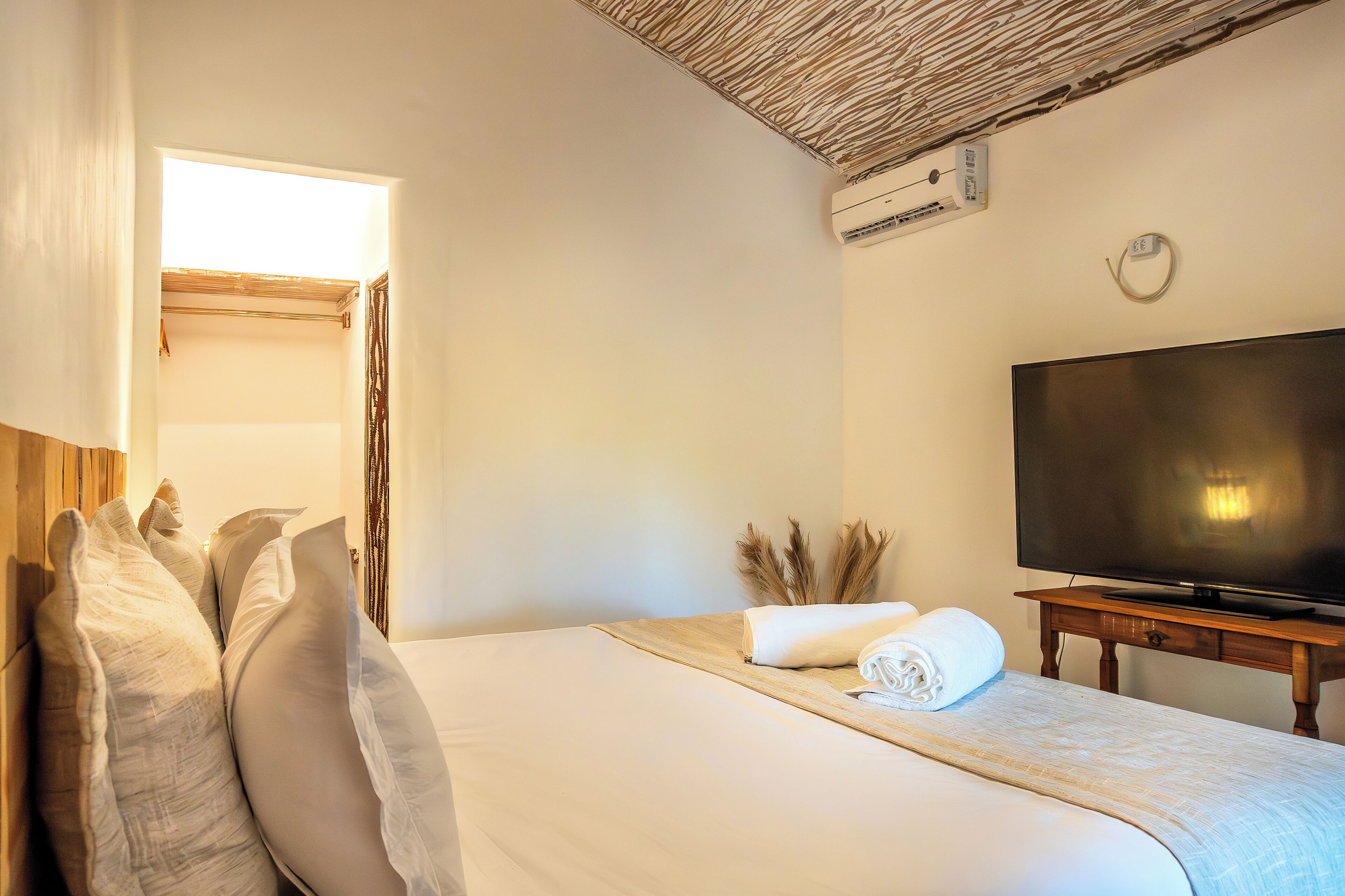 Una habitación de hotel con cama, televisor y ventana.
