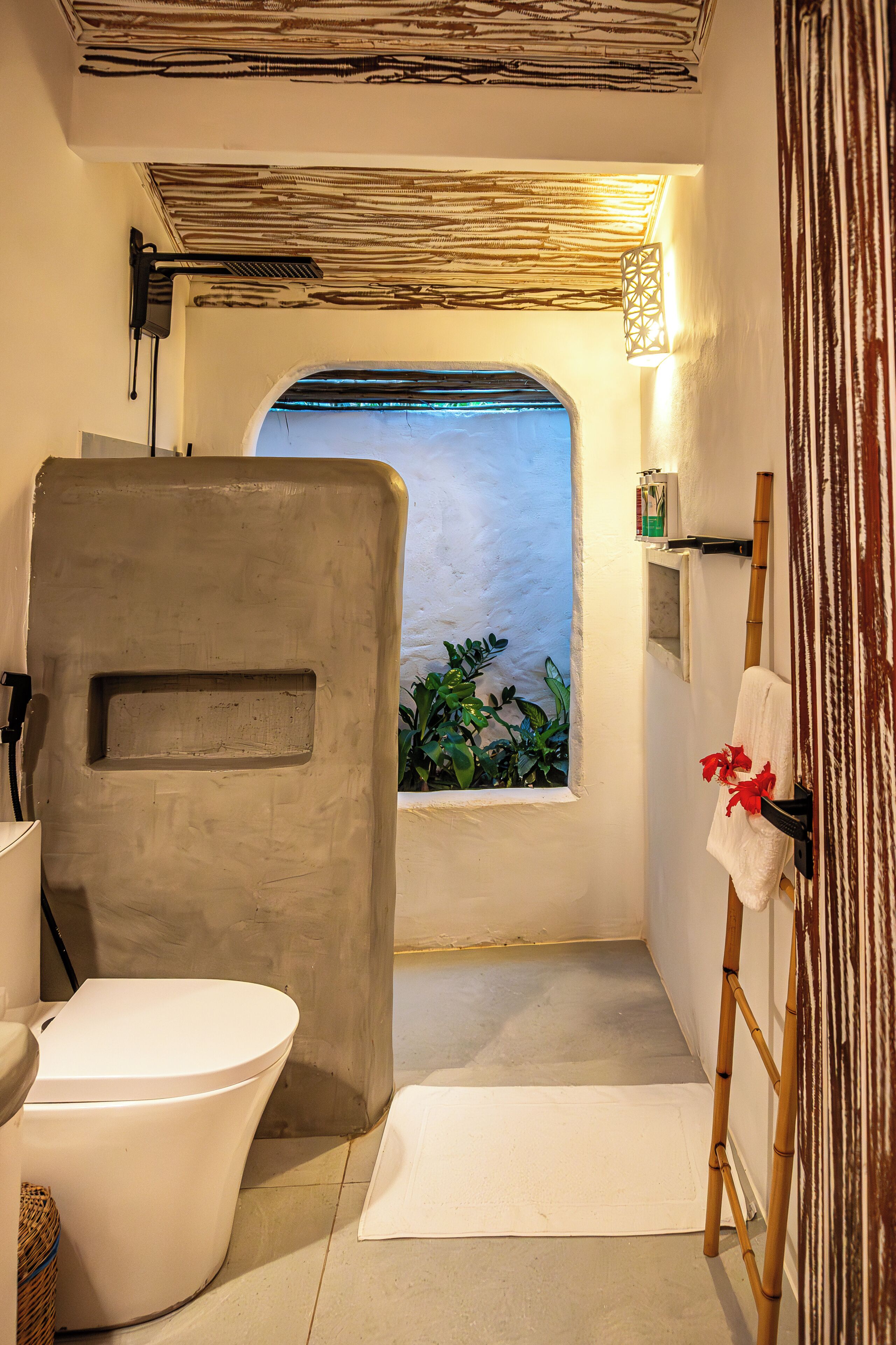 Une salle de bain comprenant des toilettes, un espace douche, une fenêtre avec vue et un porte-serviettes.